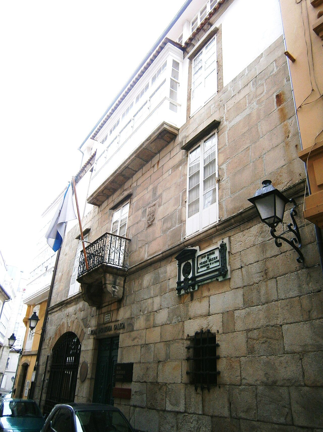 Fachada de piedra de la Casa-Museo Emilia Pardo Bazán en la calle Tabernas de A Coruña, con galerías blancas, balcón de hierro y farol