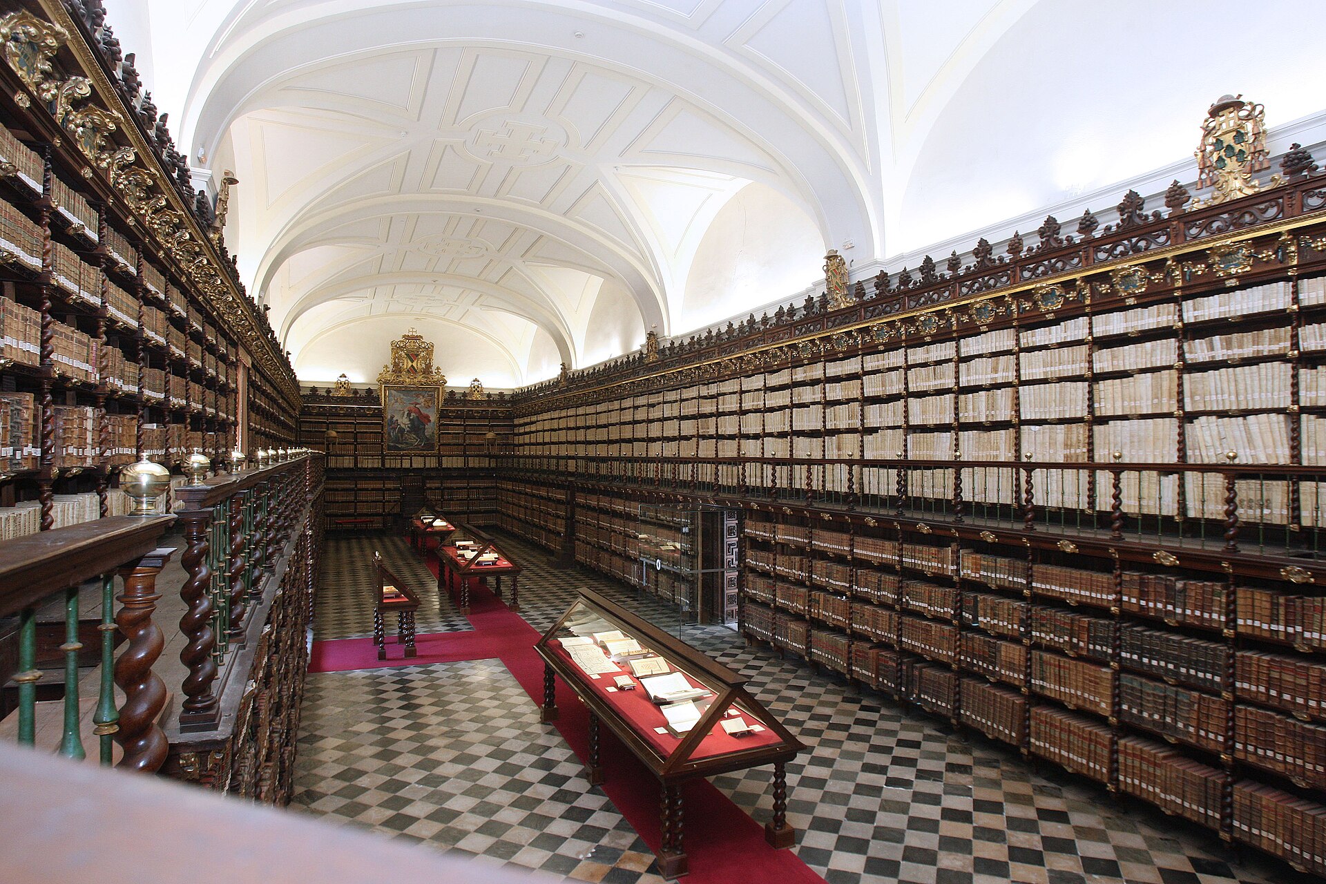 Librería de la Biblioteca Histórica de Santa Cruz, en Valladolid, con estanterías de madera en dos alturas a ambos lados de la sala