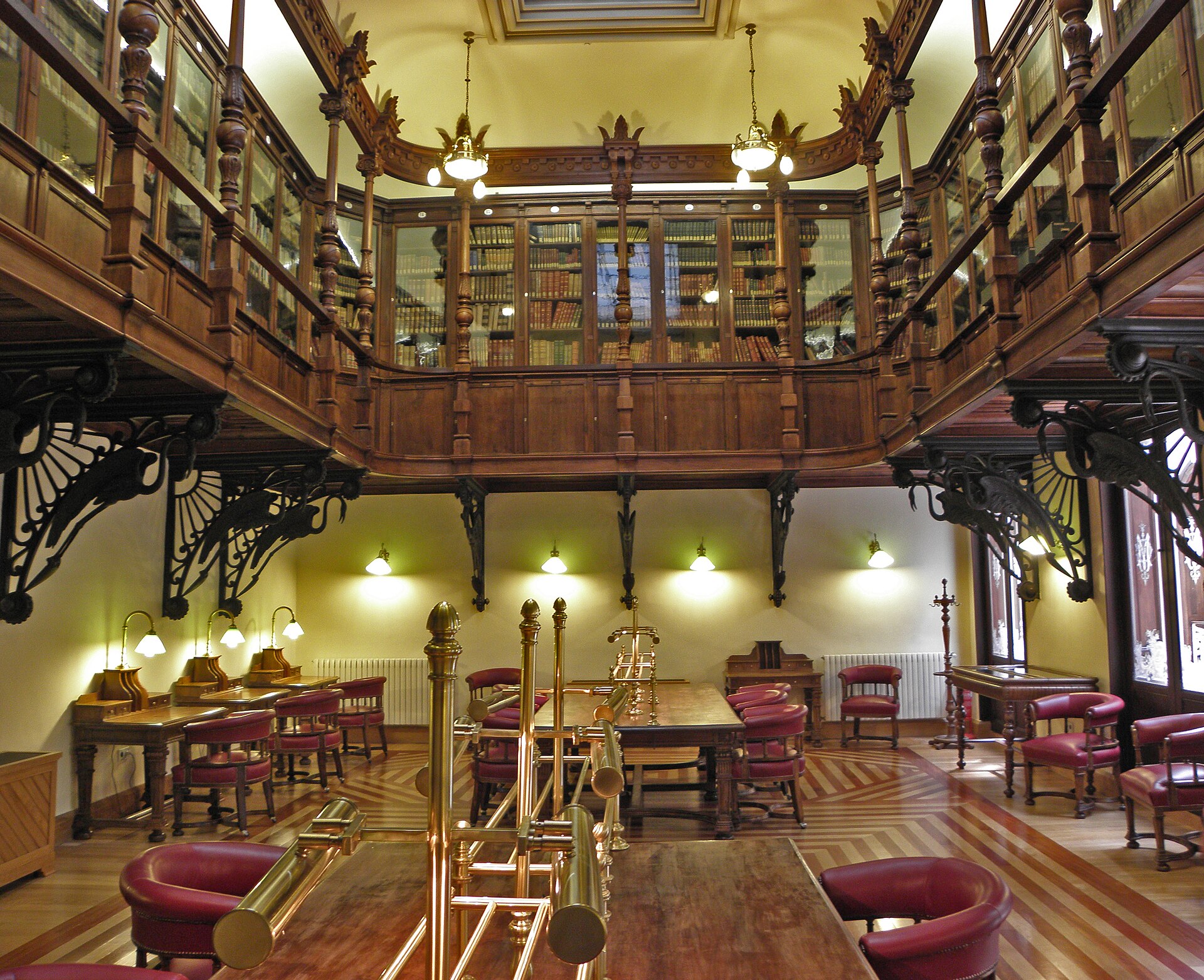 Biblioteca del Real Casino de Murcia, con su galería superior de madera sostenida por ménsulas de hierro y mesas de lectura en la planta baja