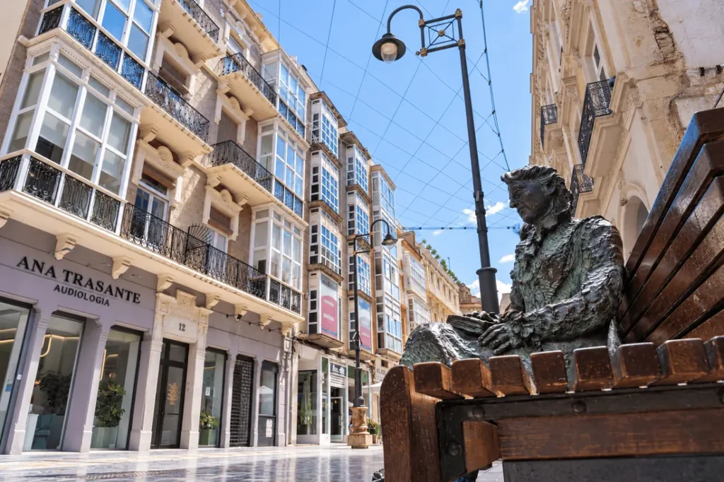 Estatua de Carmen Conde sentada en un banco en la calle del Carmen de Cartagena