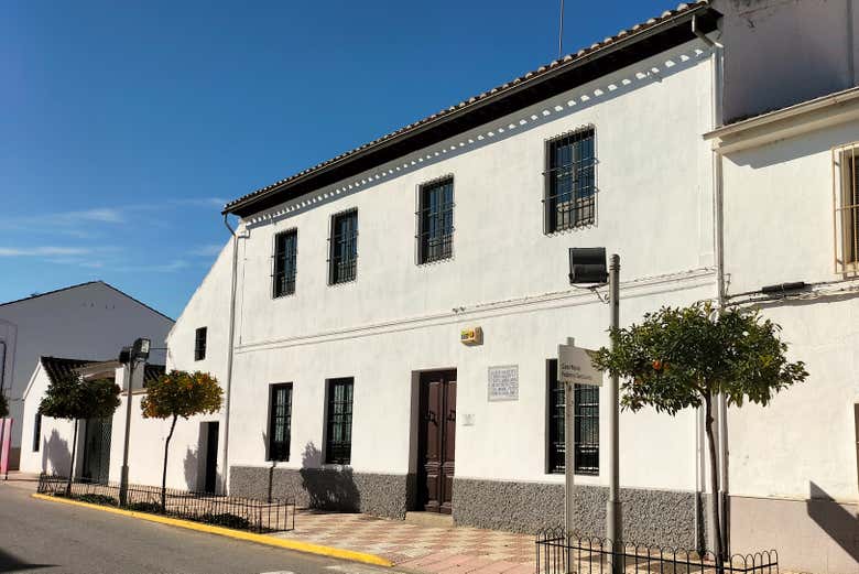 Fachada blanca de dos plantas de la Casa-Museo de Federico García Lorca en Valderrubio, con naranjos en la acera